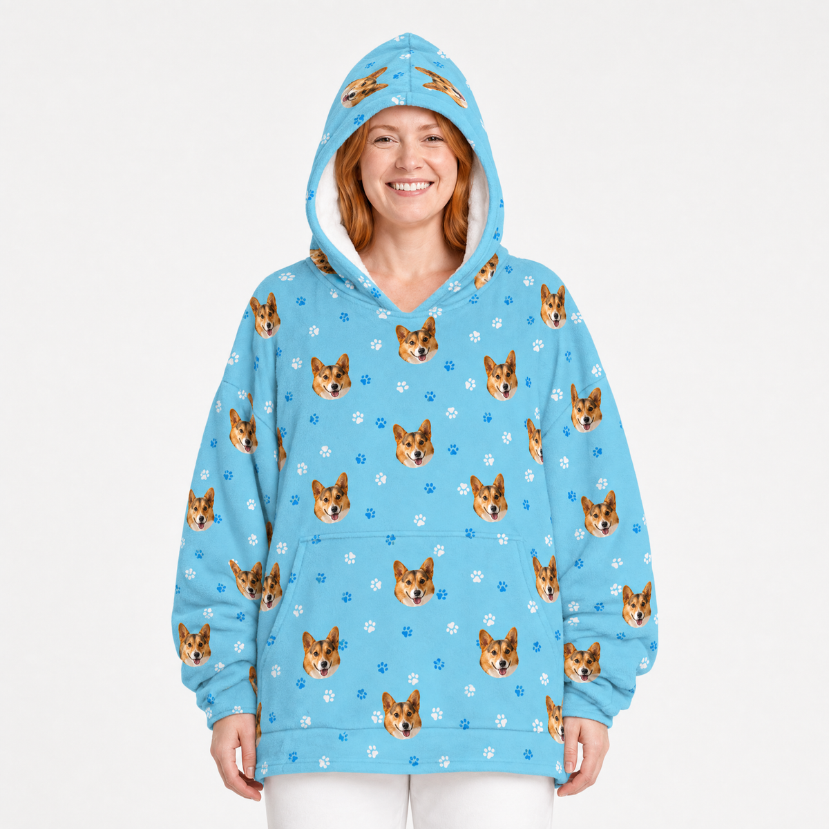 Person wearing a light blue blanket hoodie with dog pattern on a white background