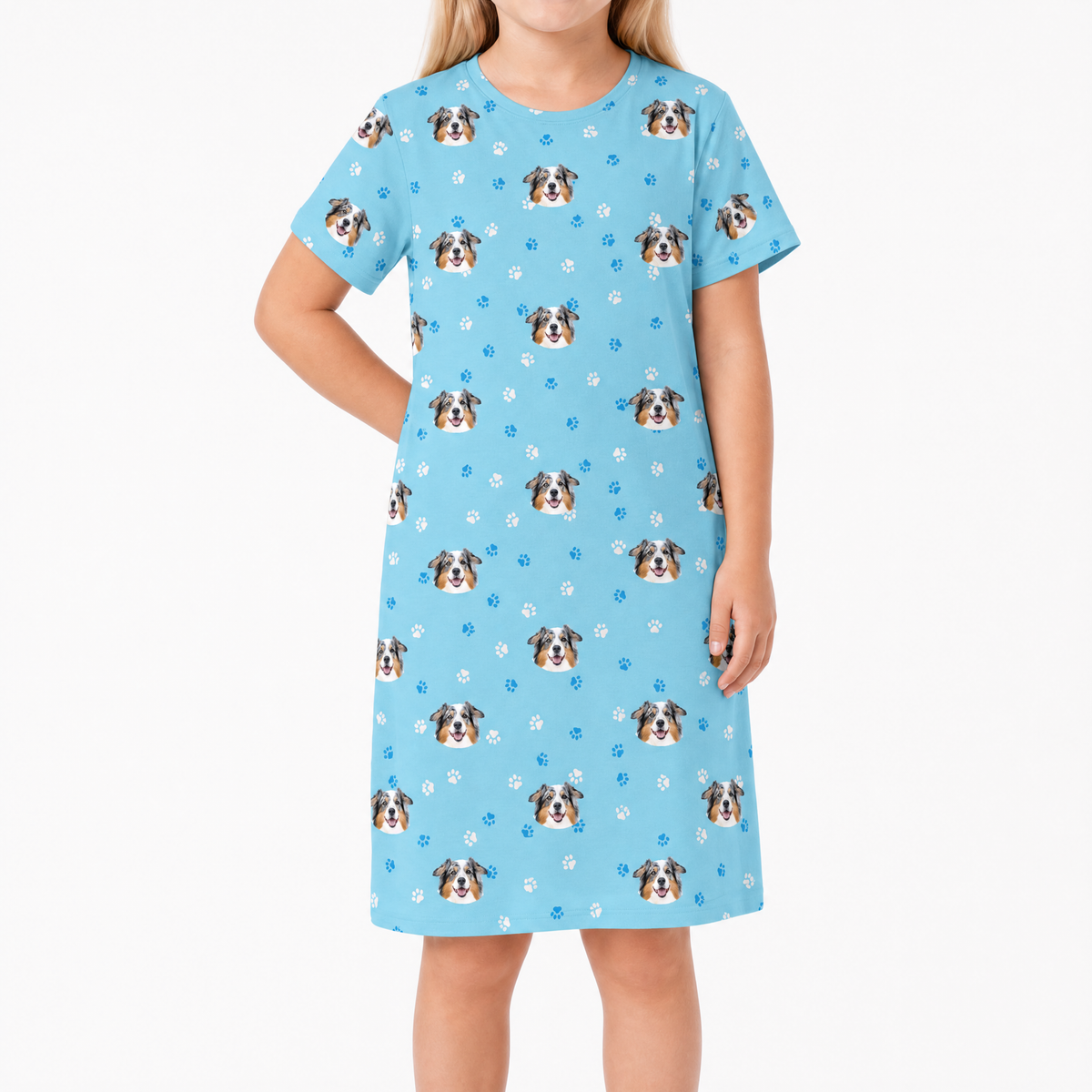 Child wearing a light blue nightgown with dog pattern on a white background