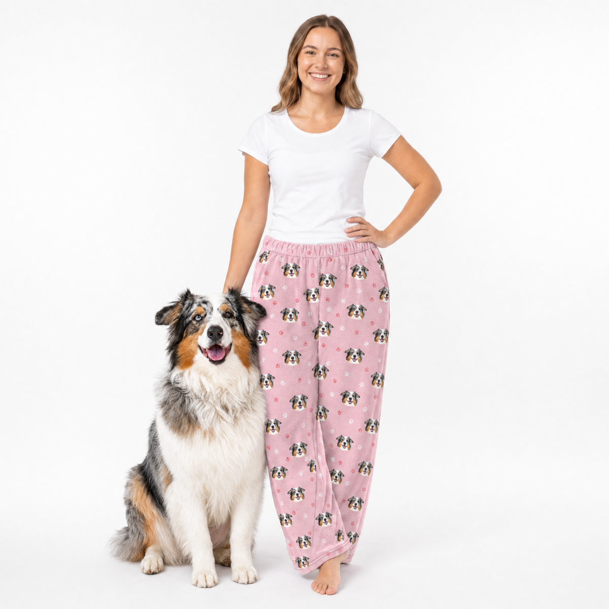 Woman wearing pink dog-patterned pajama pants with a dog on a white background