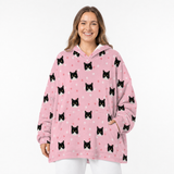 Woman wearing a pink blanket hoodie with black cat patterns on a white background