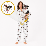 A woman wearing white pajamas with a black and tan dog print stands barefoot against a white background, holding a black-and-white dog. Two circular inset callouts highlight the dog print detail on the pajama fabric.