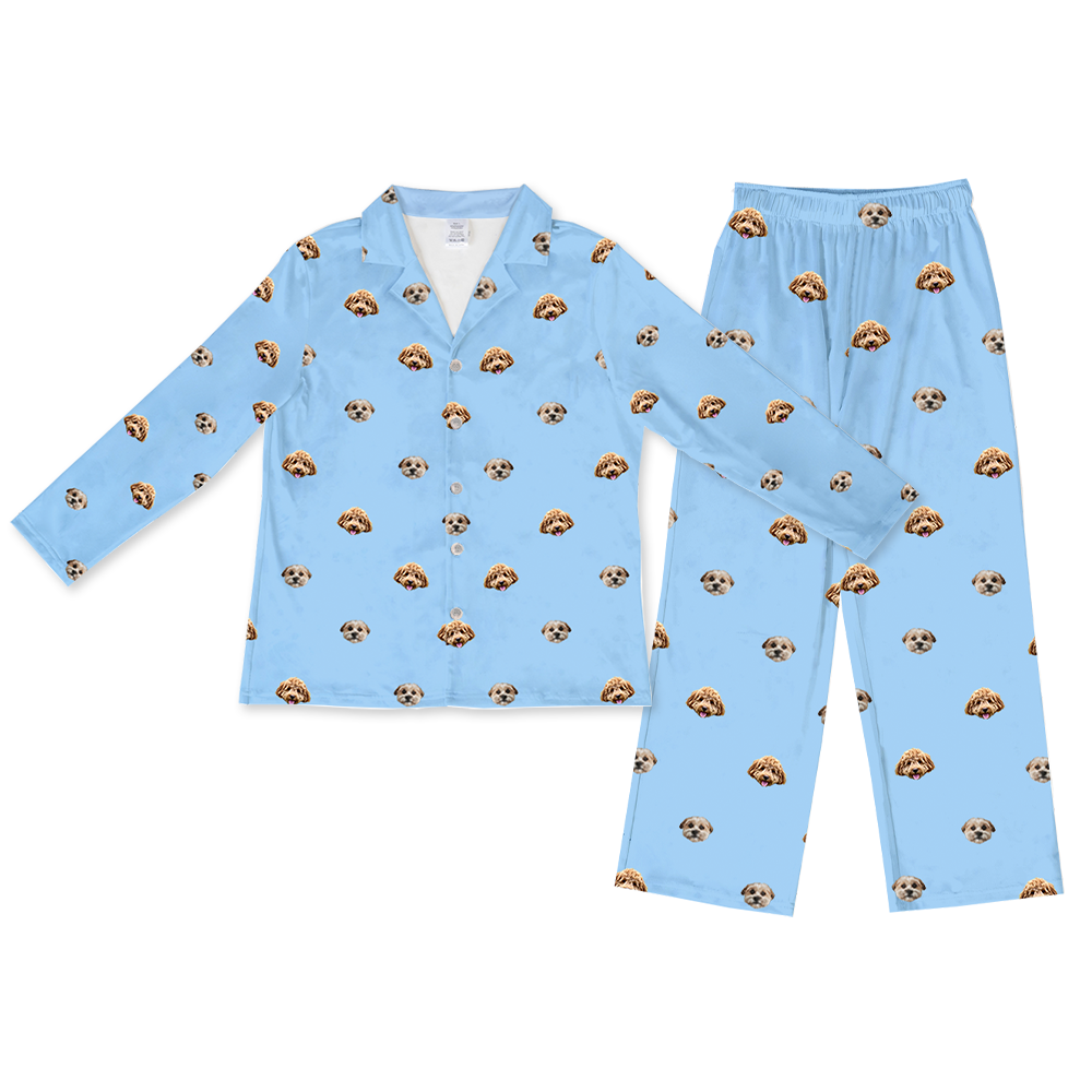A full pajama set, including a long-sleeved top and full-length pants, both in light sky blue fabric. The set features a matching repeating pattern of realistic photos of two different dogs' heads.