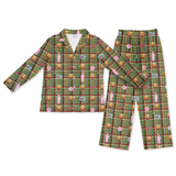 A two-piece children's pajama set featuring a long-sleeve button-up shirt and matching pants in a green plaid pattern with cartoon dog faces, pink bows, and small novelty labels, shown on a plain white background.