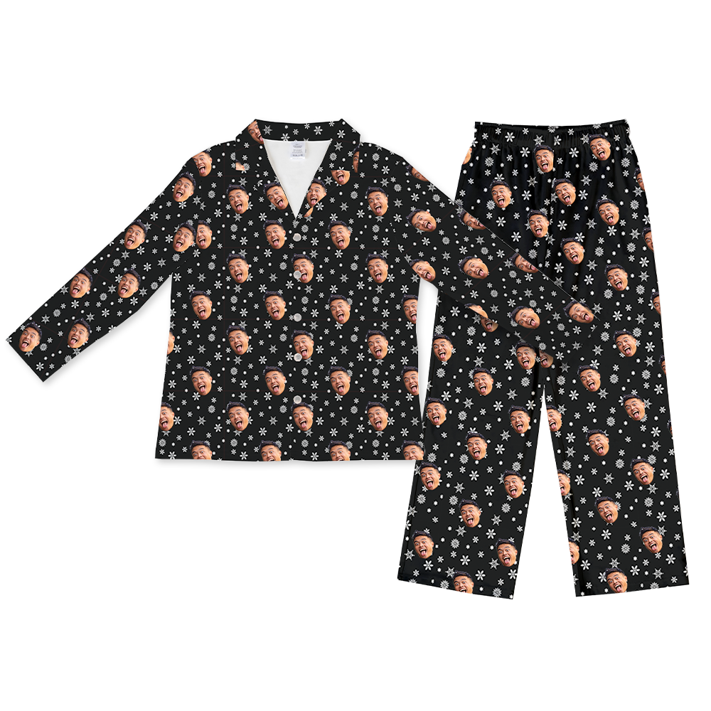 Two-piece long-sleeve pajama set with an all-over print featuring a smiling face on a black background decorated with white snowflakes.