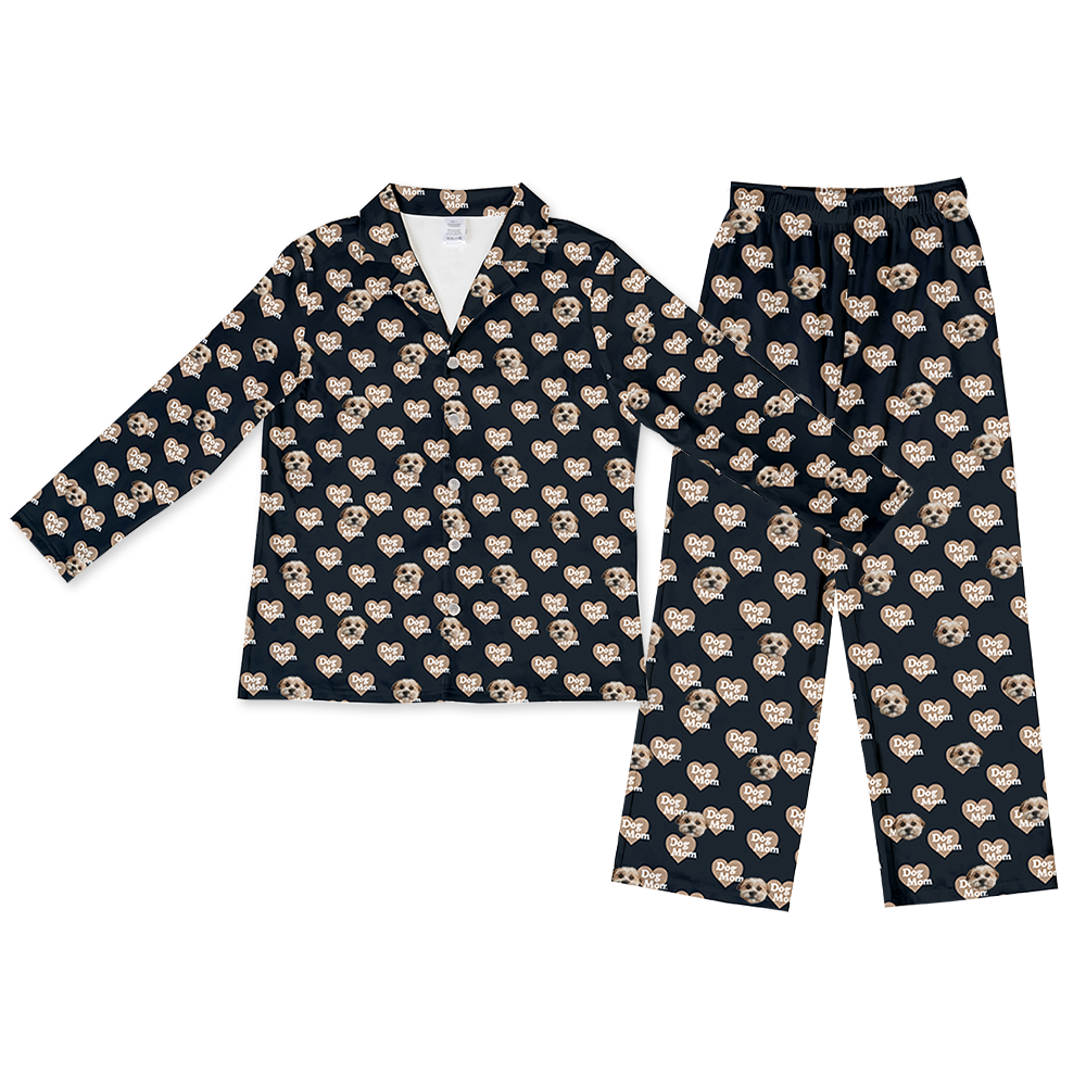 Black two-piece pajama set with a long-sleeve button-down top and matching pants, featuring an all-over pattern of dog faces and heart-shaped ‘Dog Mom’ icons.