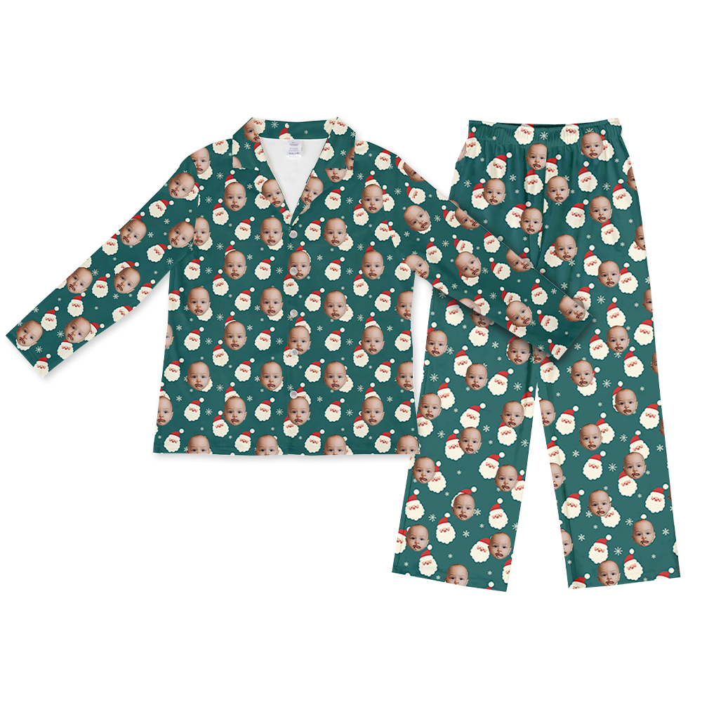 Teal long-sleeve button-up pajama top with matching pants, featuring a repeating holiday pattern of a baby’s face, Santa faces, and small snowflakes across the fabric.