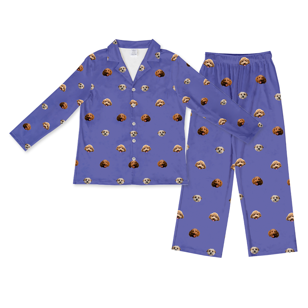 A matching long-sleeve pajama set (button-down shirt and full-length pants) in a solid medium purple/grape color. The fabric is covered in a repeating, all-over pattern of small, cropped dog faces, featuring three different dog types. 