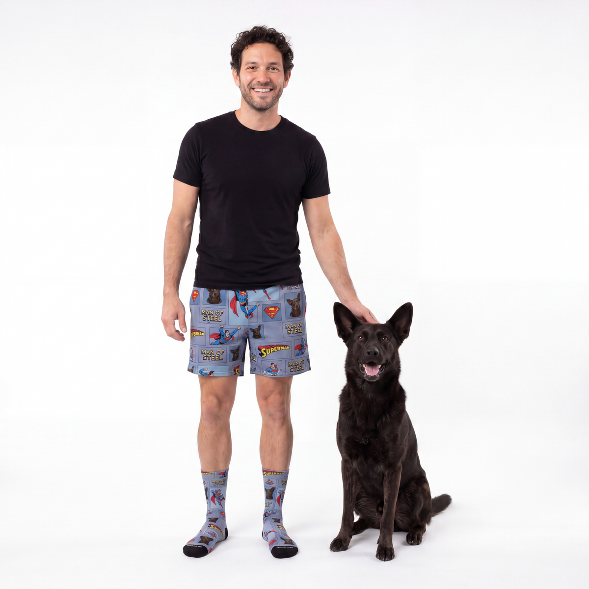 Man wearing superman pajama shorts with a dog on a white background