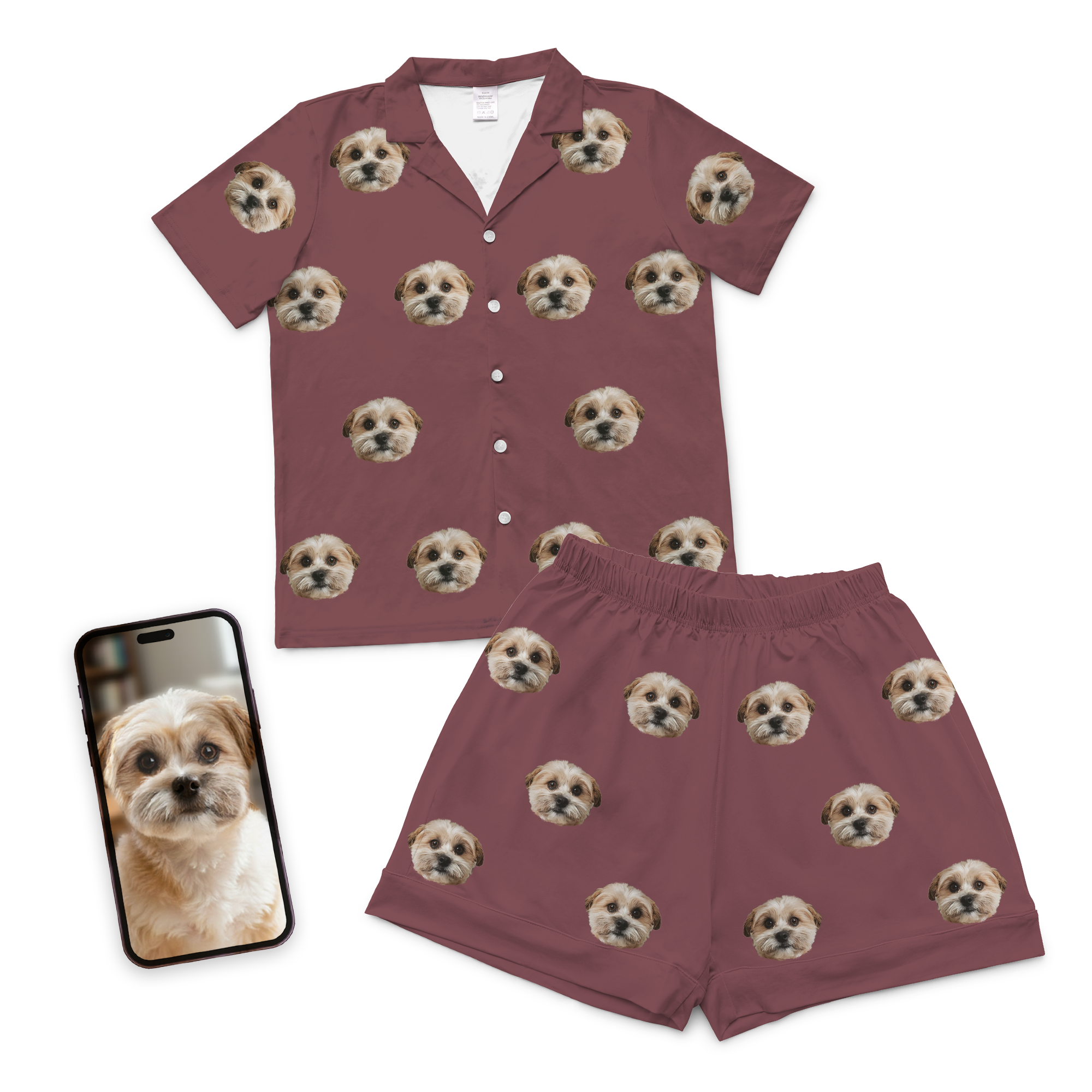 Custom Pet Face Pajamas – Maroon: This short-sleeve button-up shirt and shorts set features a repeated print of your pet’s face, making it the ideal personalized gift for pet lovers. A nearby smartphone displays the matching dog photo.
