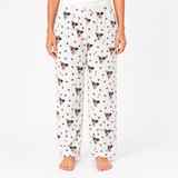 White pajama pants with dog pattern worn by a person on a white background