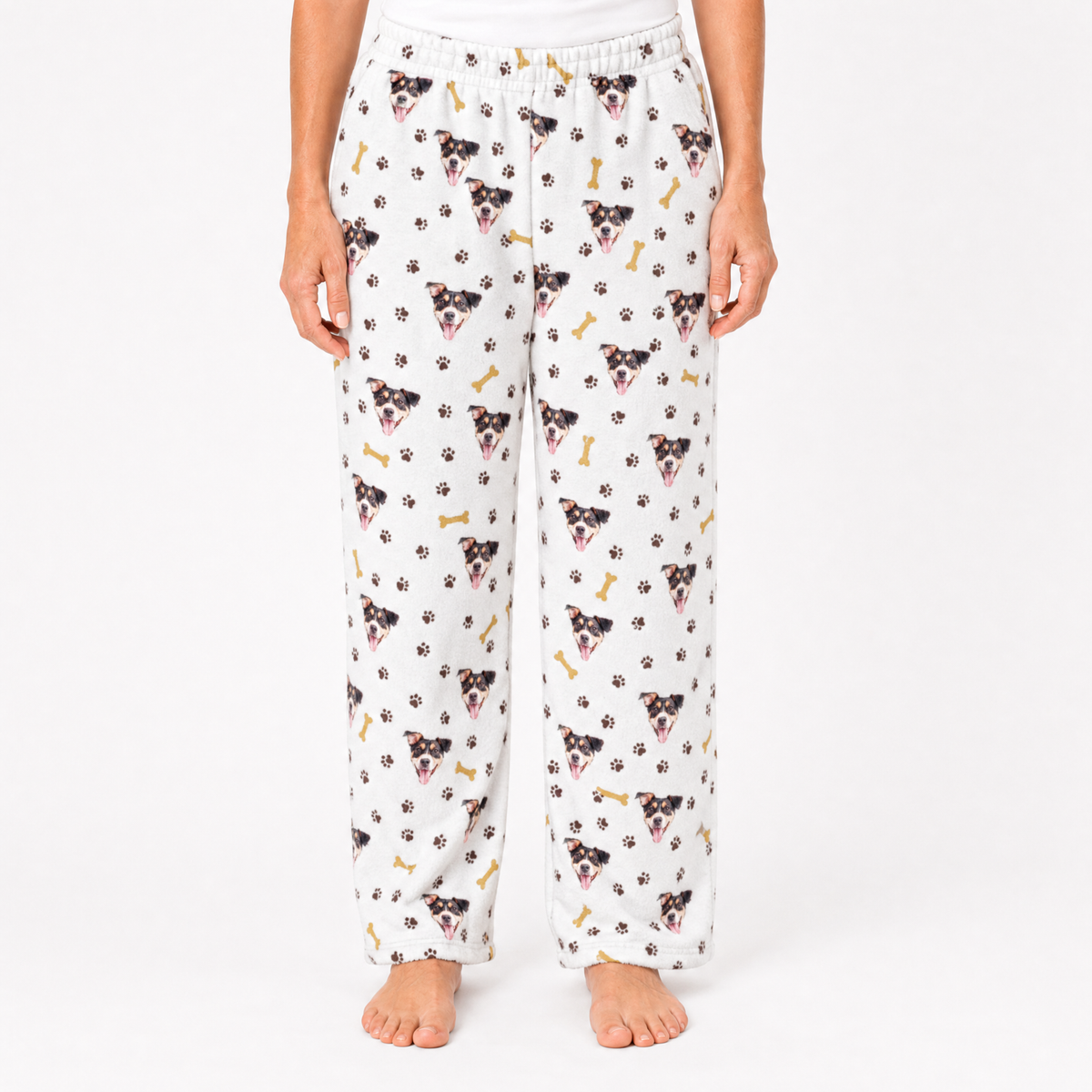 White pajama pants with dog pattern worn by a person on a white background