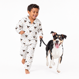 Child in white pajamas with a dog on a white background