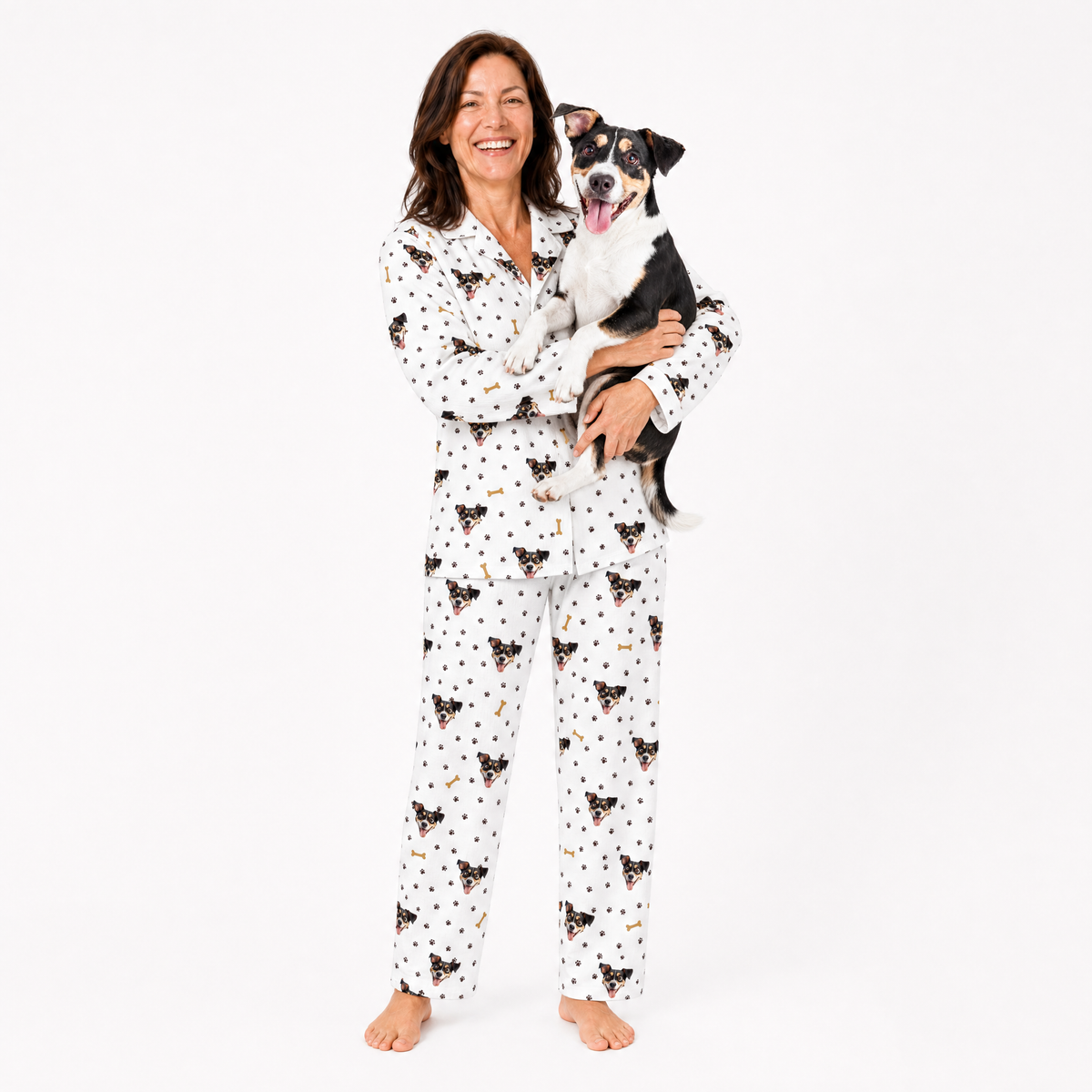 Woman wearing a patterned pajama set holding a dog on a white background