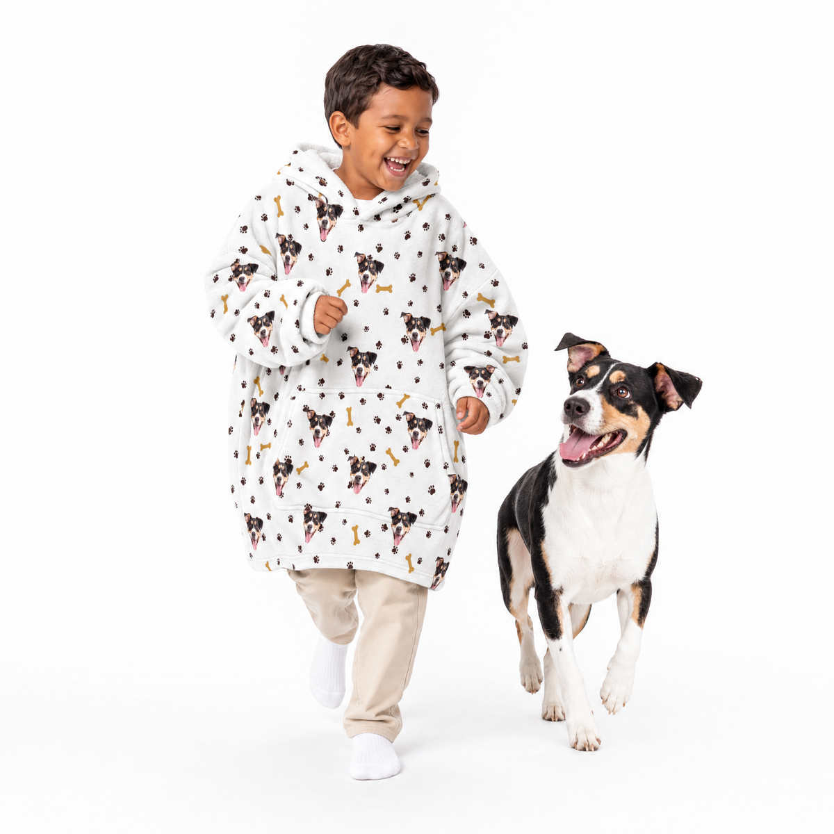 Child wearing a dog-themed blanket hoodie with a dog walking next to them on a white background