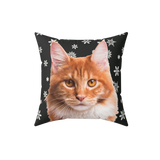 Pillow with a cat face design on a black background with white snowflakes