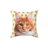 Beige pillow with gingerbread pattern and the face of a cat.