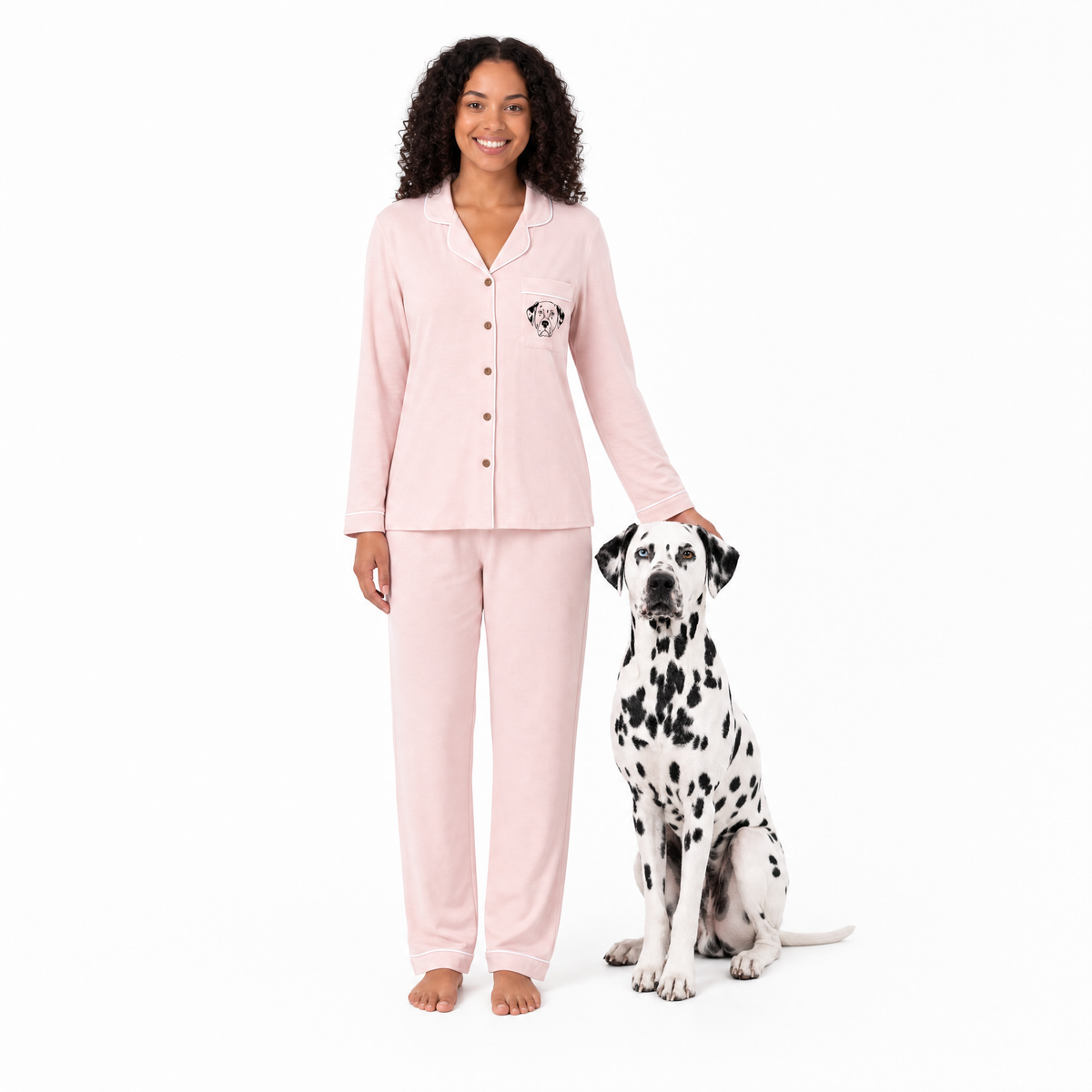 Woman in pink pajamas with a Dalmatian dog on a white background