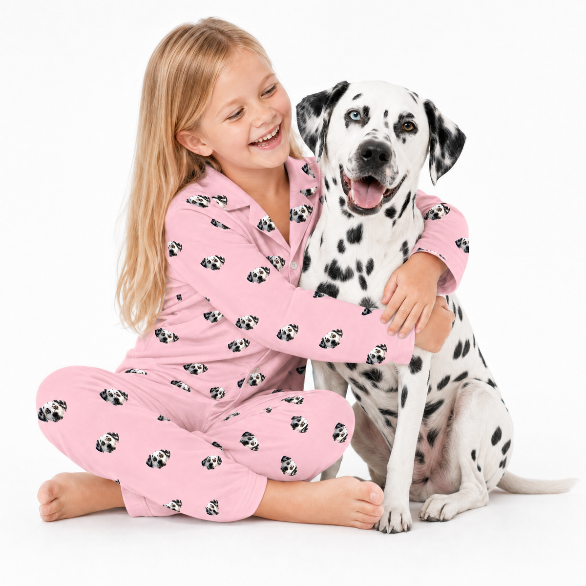 Girl in pink pajamas with a Dalmatian dog on a white background