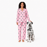 Woman wearing pink pajamas with a dog on a white background