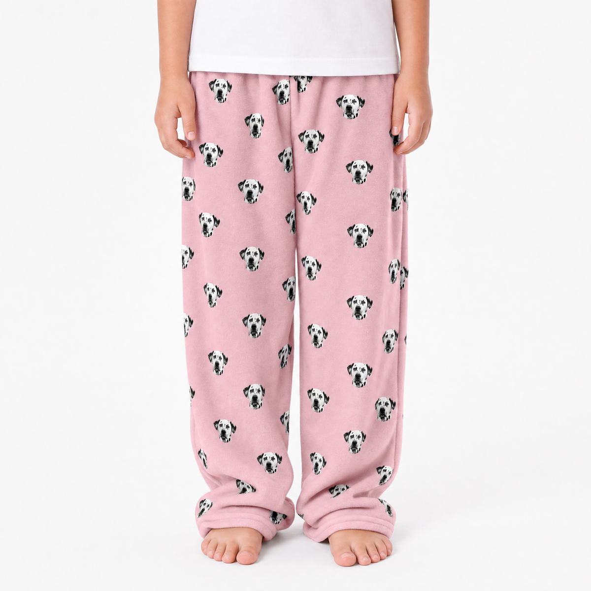 Pink pajama pants with dog pattern worn by a person on a white background