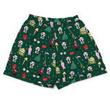 A pair of dark green shorts featuring a festive Christmas-themed print with Dalmatian dogs, Santa Claus, Christmas trees, and holiday houses on a white background.