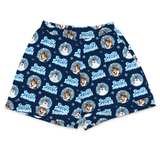 A pair of navy blue boxer shorts featuring a repeating 'Freezy Snowman' pattern with cartoon dogs, snowmen, and light blue snowflakes on a white background.