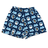 A pair of navy blue boxer shorts featuring a repeating 'Freezy Snowman' pattern with cartoon dogs, snowmen, and light blue snowflakes on a white background.
