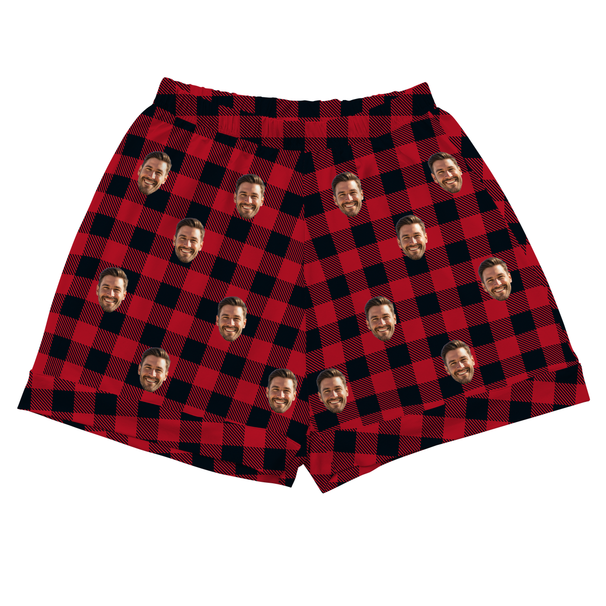 A pair of pajama shorts with an elastic waistband, featuring a classic red and black buffalo plaid pattern. Repeated headshots of a smiling, bearded man are superimposed onto the plaid fabric. 
