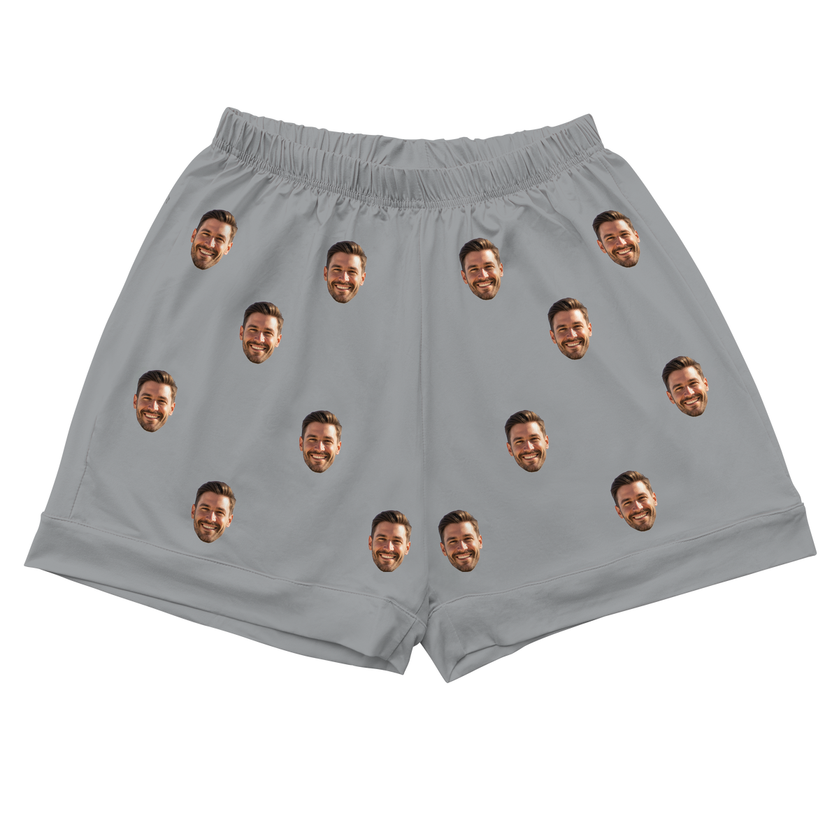 A pair of athletic or pajama shorts with a gathered, elastic waistband, made from a solid slate gray fabric. Repeated headshots of a smiling, bearded man's face are evenly spaced and superimposed across the fabric.