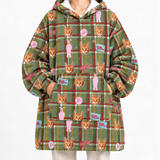 A person wearing an oversized hooded sweatshirt with a green plaid pattern and repeated cat face prints, shown against a plain light background.