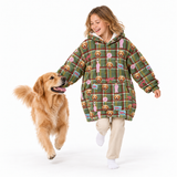A young girl wearing a green plaid hooded sweatshirt with a dog-themed print is running playfully with a golden retriever on a white studio background.