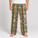 A person wearing green plaid pajama pants with corgi face prints, pink bows, and small decorative patches, shown from the waist down on a light gray studio background.