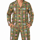 A man wearing a matching long-sleeve button-up pajama top and pants set in an olive green plaid pattern with golden retriever dog faces, pink silhouettes, and small colorful patches, photographed against a plain white background.