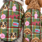 Two dogs wearing matching Christmas-themed plaid dog jackets. The jackets feature a green, red, and yellow plaid pattern with cartoon dog faces, a pink bunny in a onesie, and holiday text like 'A Christmas Story' and 'It's a pink nightmare'.