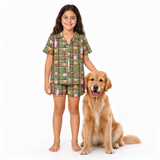 Young girl standing next to a Golden Retriever dog, wearing a green plaid short-sleeve pajama set featuring a Golden Retriever print with pink A Christmas Story bunny suit patterns.
