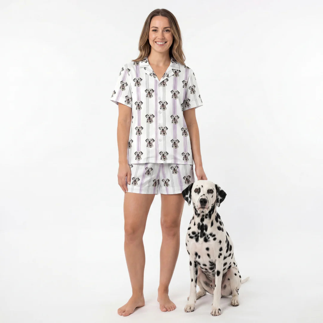 Woman wearing a patterned pajama set standing next to a Dalmatian dog on a white background [LilacStripes]
