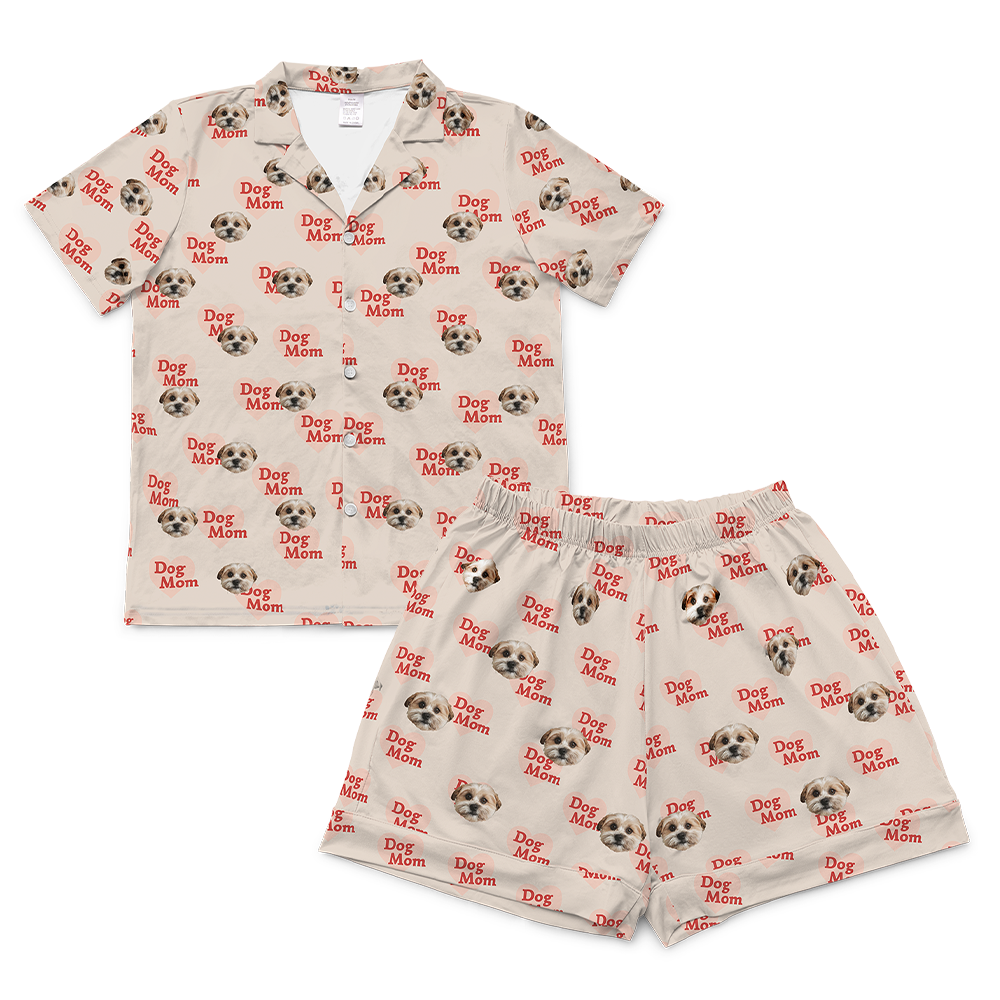 A matching short-sleeve pajama set (top and shorts) rendered in a dark green fabric. The entire set is covered in a repeating golf-themed pattern featuring alternating elements: white golf balls, light yellow golf tees, and dog faces.