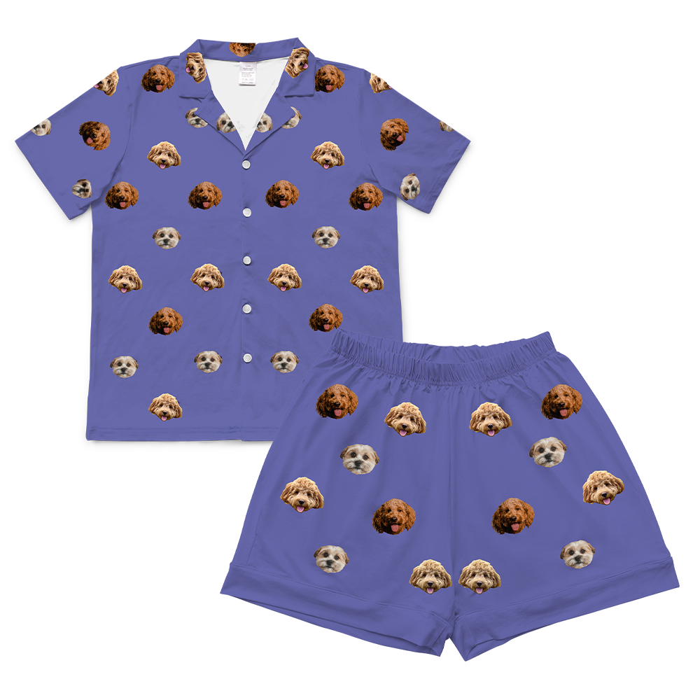 A set of short-sleeve pajamas in a deep grape purple color. The fabric features a repeating pattern of small, cropped photos of three different dogs' faces.