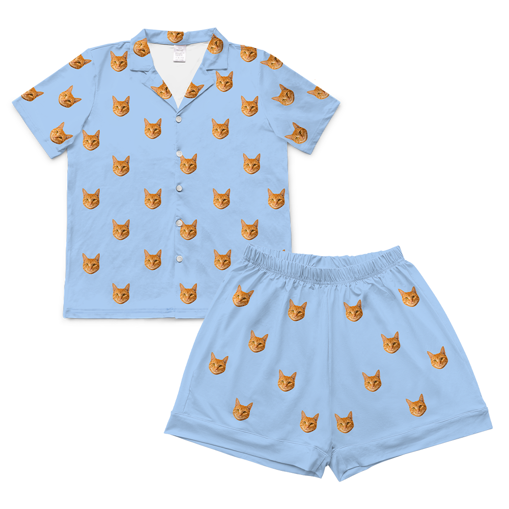 Sky blue pajama set with orange cat faces on a white background