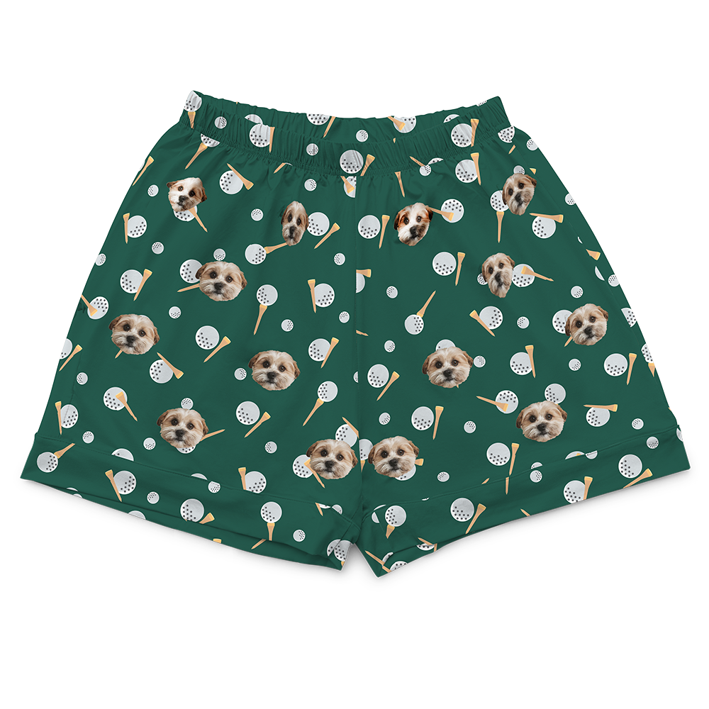 Green shorts with dog and golf balls pattern on a white background
