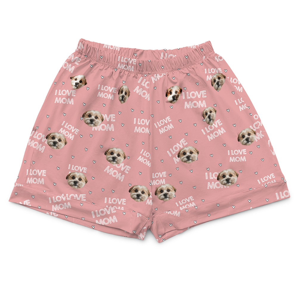 Light pink pajama shorts with an elastic waistband, patterned with a single type of dog face, tiny hearts, and the phrase "I LOVE MOM."