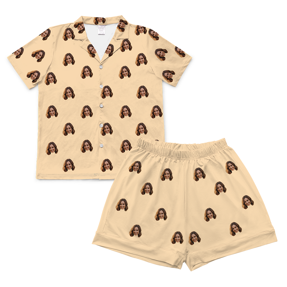 Butter-yellow short-sleeve button-up pajama shirt with matching shorts, decorated with a repeating pattern of the same smiling woman’s face across both pieces.