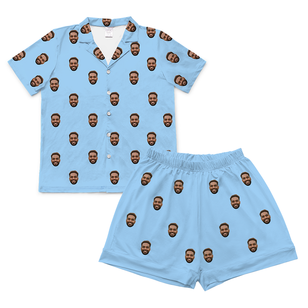 A two-piece set of short-sleeve pajamas in a solid light blue. The pajamas are customized with multiple small, repeating images of a man's smiling face with a beard, covering the entire fabric of both the shirt and the shorts.