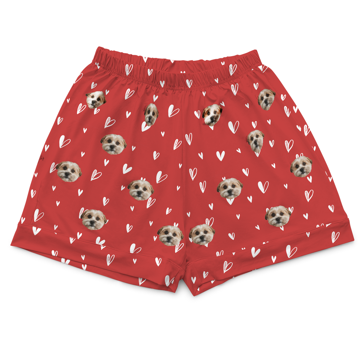 A pair of short pajama shorts in a vibrant red color with an elastic waistband. The shorts are patterned with small, white, hand-drawn outline hearts. The main motif is a repeating pattern of small, cropped photos of a single dog's face.