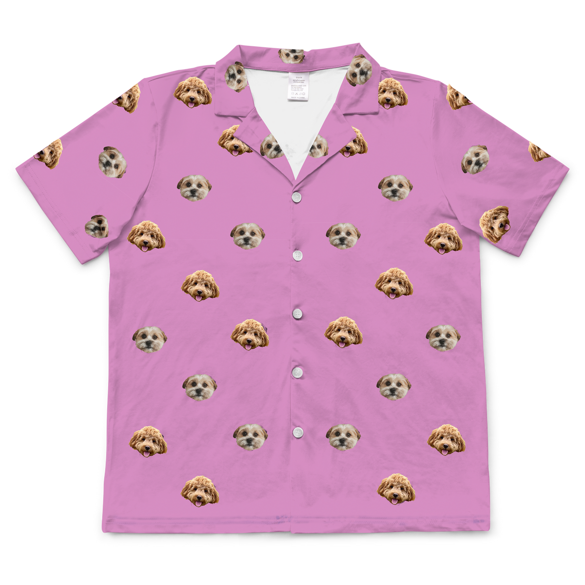 An orchid pink, short-sleeved pajama top with a button-down front and collar. The top features a repeated pattern of two different dogs' faces, one light brown and one light brown and white.