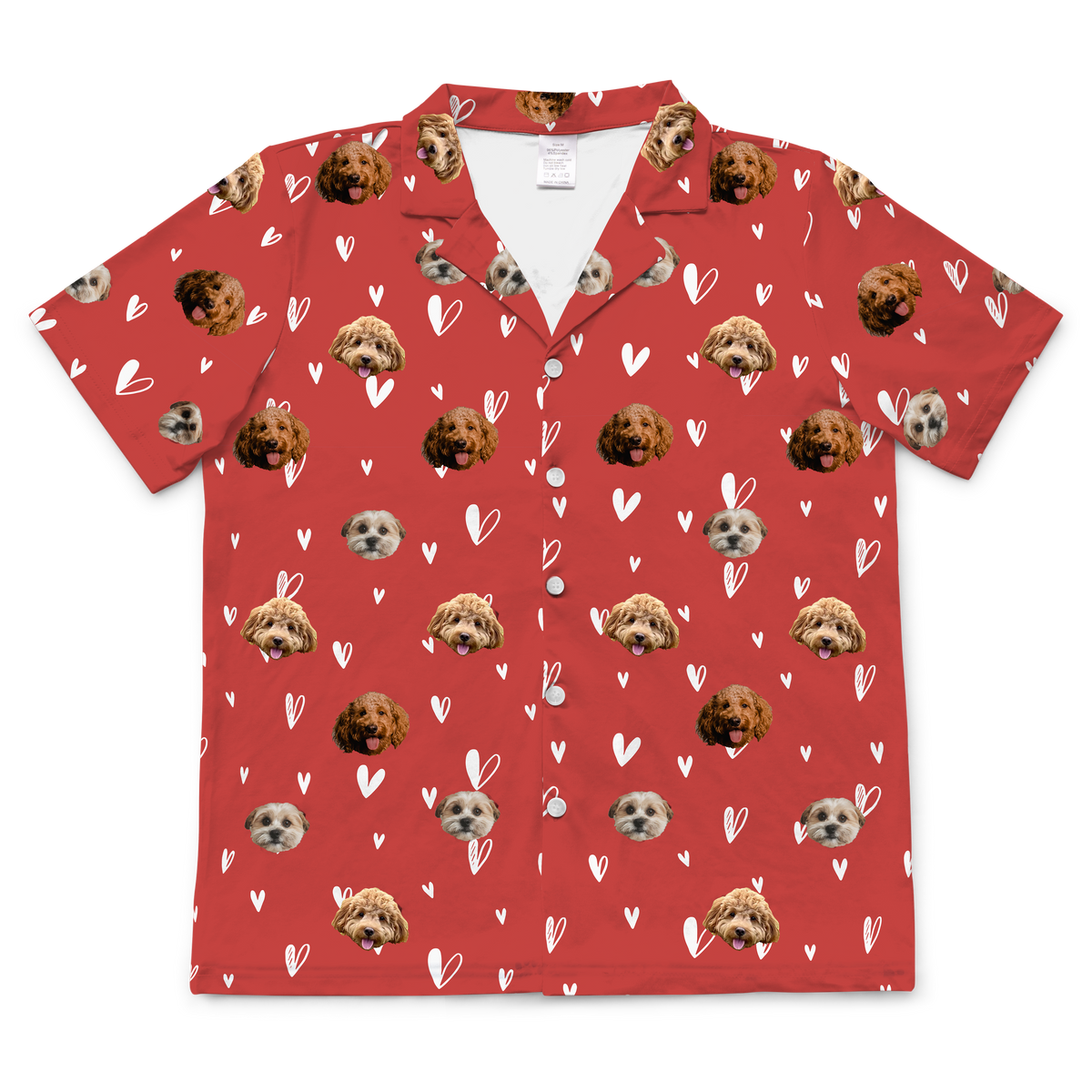 A single short-sleeve, collared, button-down pajama shirt in a vibrant red color. The fabric is patterned with small, white, hand-drawn outline hearts. The main motif is a repeating pattern of small, cropped photos of three different dogs' faces.