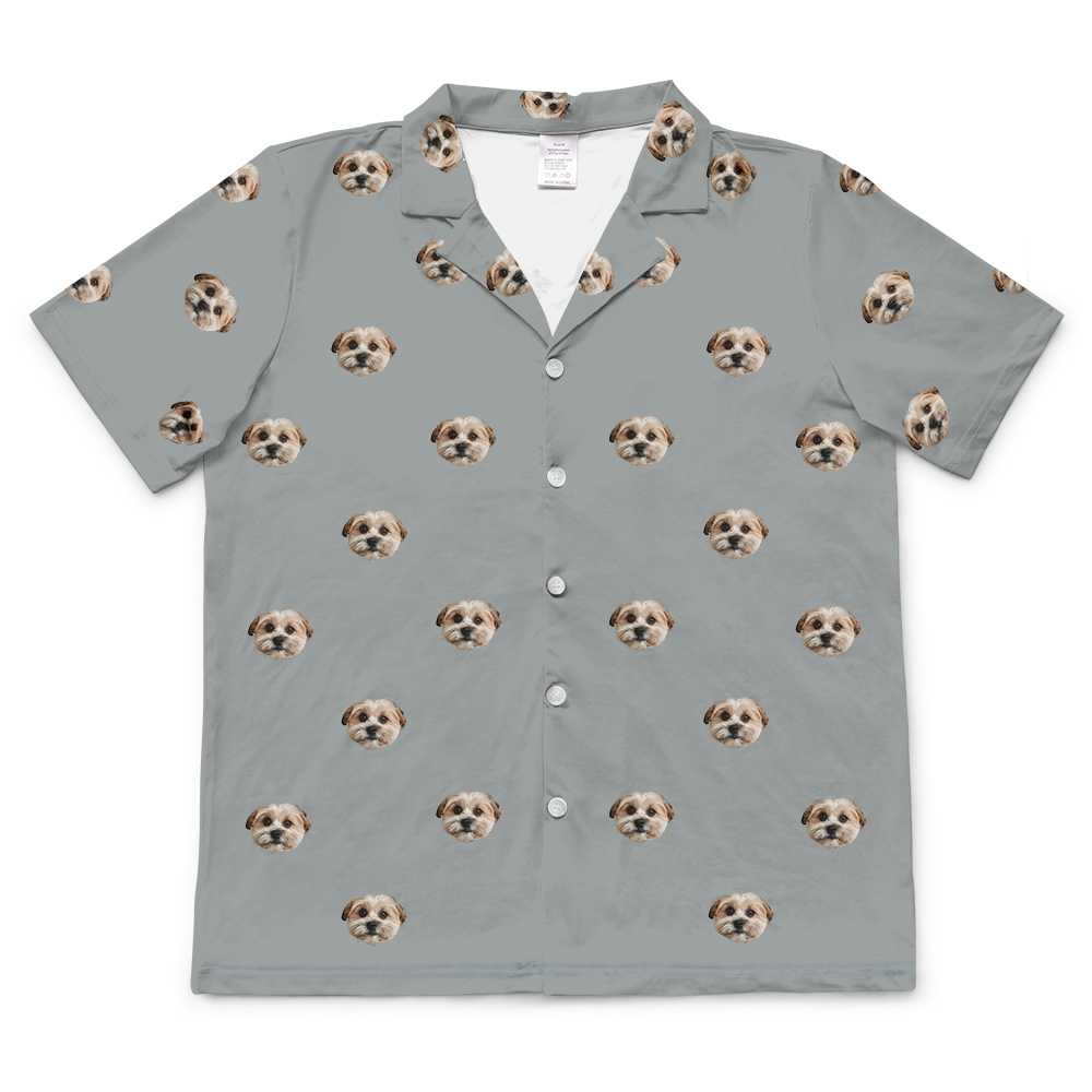 
A short-sleeved, button-up pajama top in slate grey fabric. The top features a repeating pattern of realistic photos of a single small dog's head.