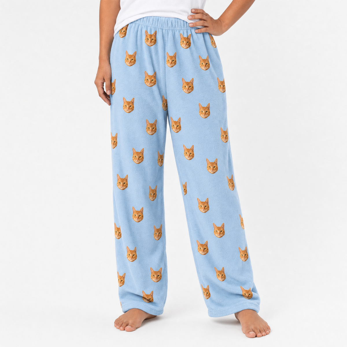 Sky blue pajama pants with cat pattern worn by a person on a white background