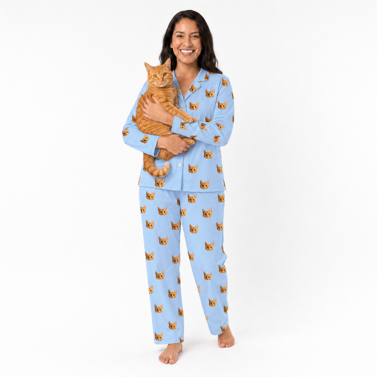 Woman wearing sky blue pajamas with cat pattern, holding an orange cat on a white background