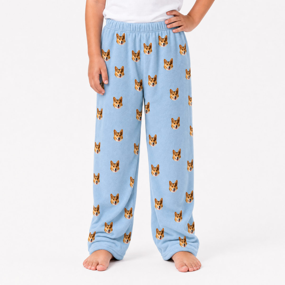Sky blue pajama pants with dog pattern worn by a person on a white background